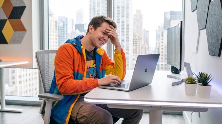 Un giovane davanti al computer tira un sospiro di sollievo dopo un esame online: come funziona l'esame di un corso con attestato